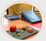 eine Bewegungslandschaft aus Matten, Kasten, Kletternetz in einem Gymnastikraum