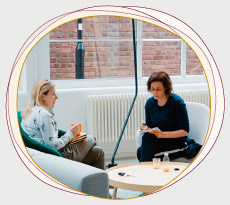 Zwei Frauen in einem Workshopraum im Gespräch