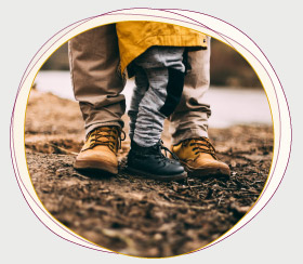 Ein Vater steht draußen schützend hinter seinem kleinen Kind